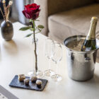 romantisk pakke på hotelværelset med rød rose og petitforurs. champagne på køl.