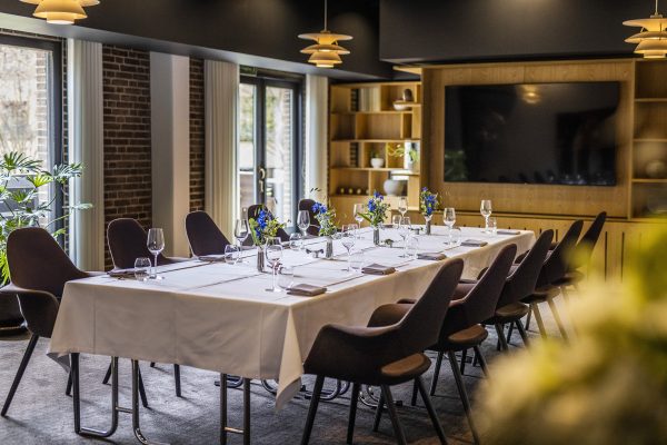 flolt dækket bord i intime rammer med blomster og glas på bordene