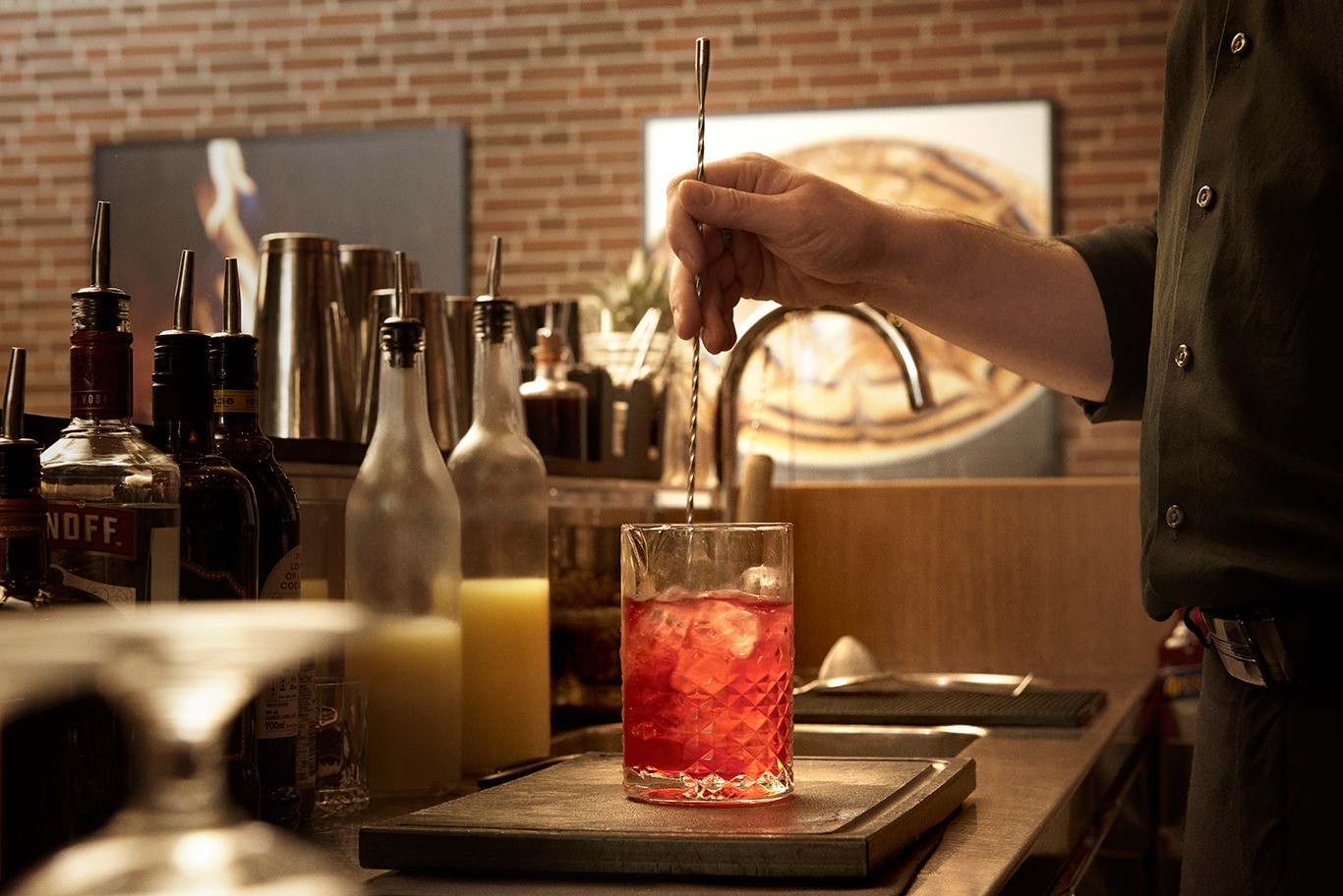 tjener mixer rød cocktail i bar