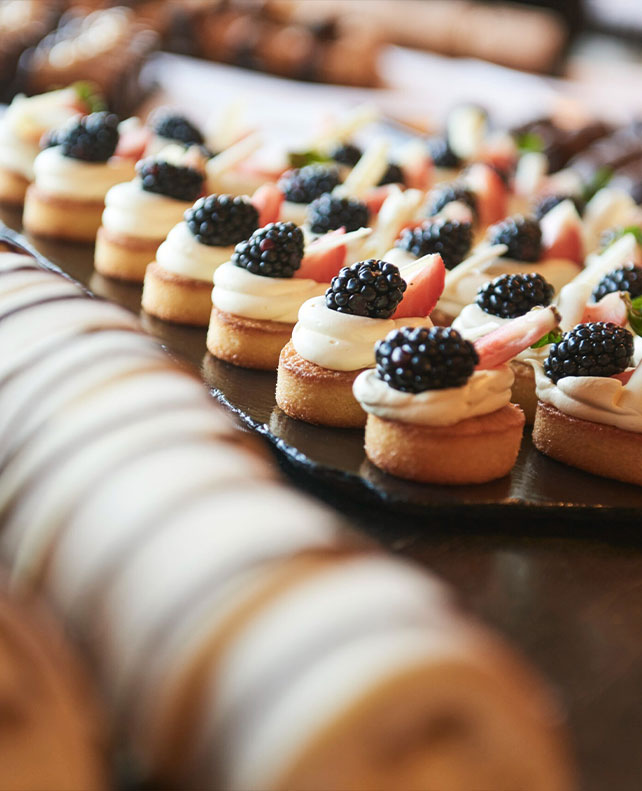 små kager med creme og brombær